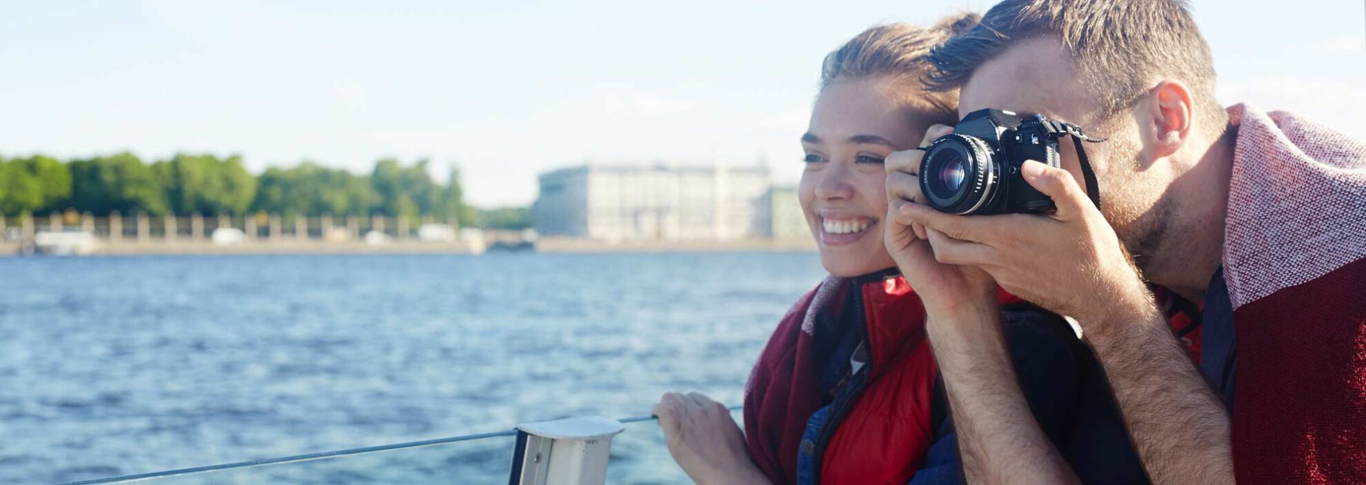junger Mann fotografiert während einer Kreuzfahrt die Sehenswürdigkeiten des Flusses